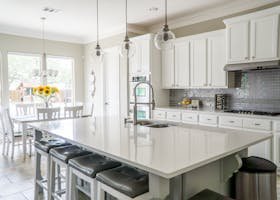 Spacious modern kitchen with white cabinets and island in natural light.